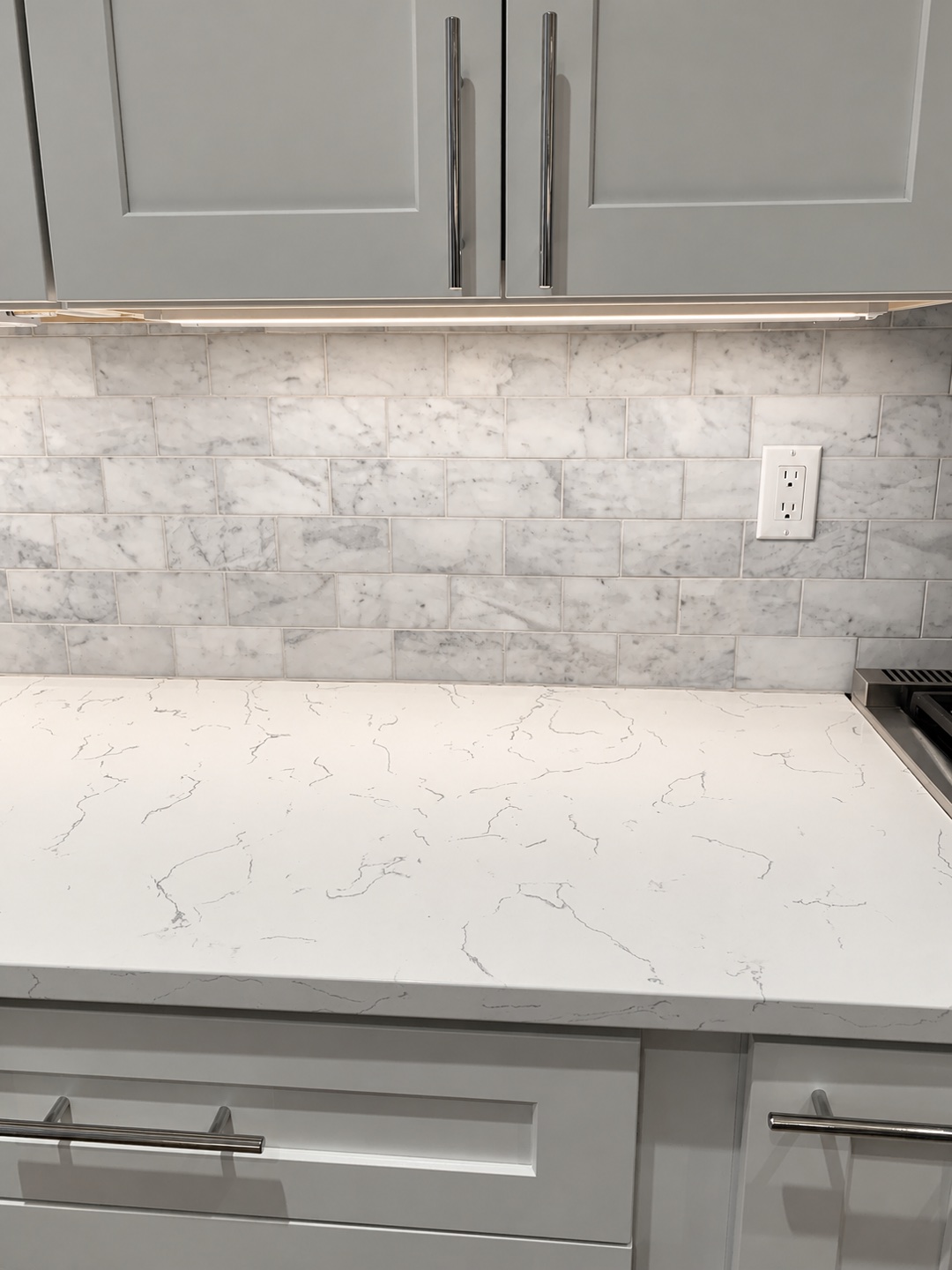 Kitchen countertop, tile backsplash, and under-cabinet lighting detail