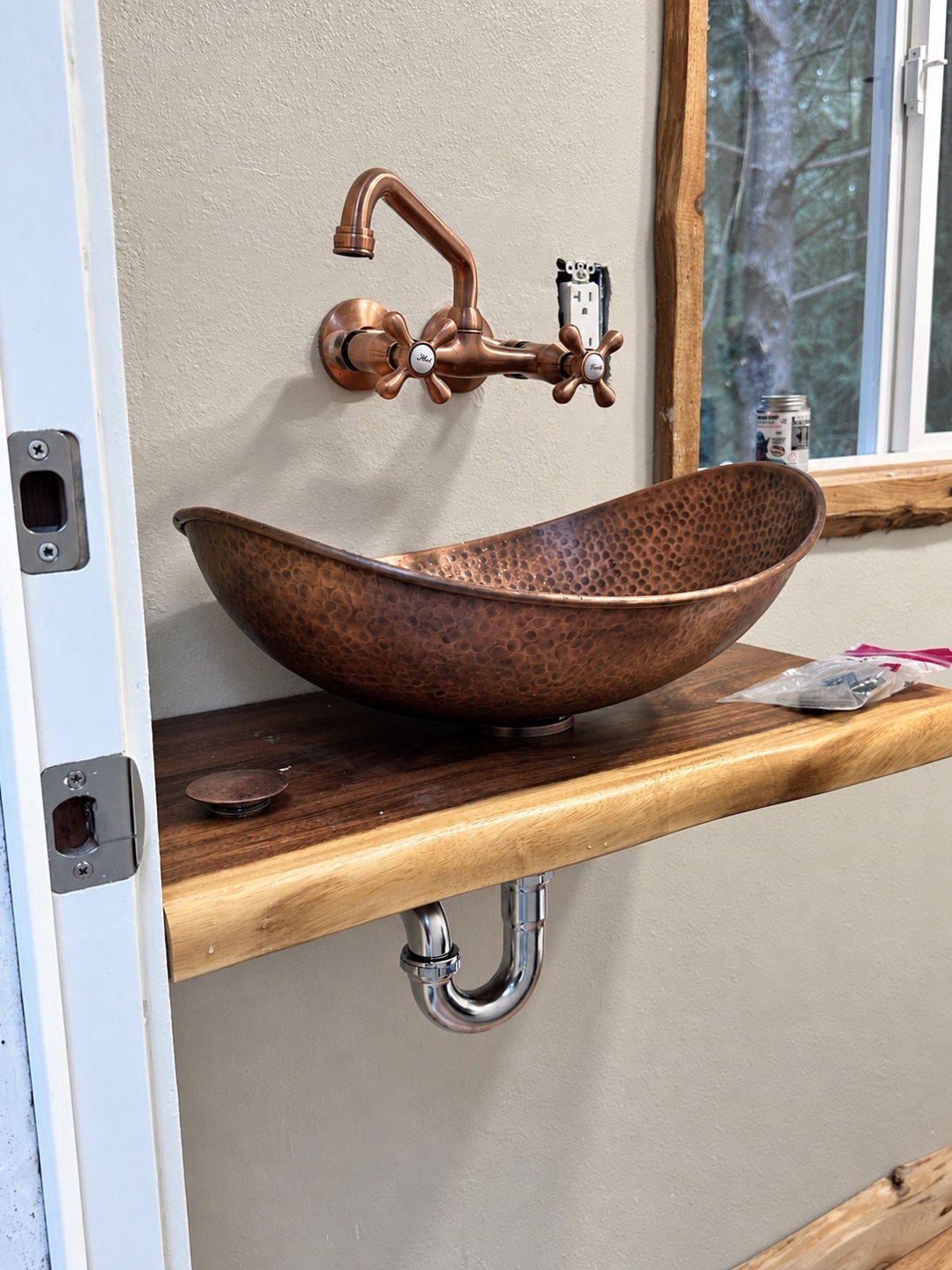 Copper vessel basin on a natural wood countertop during installation, before final finishing