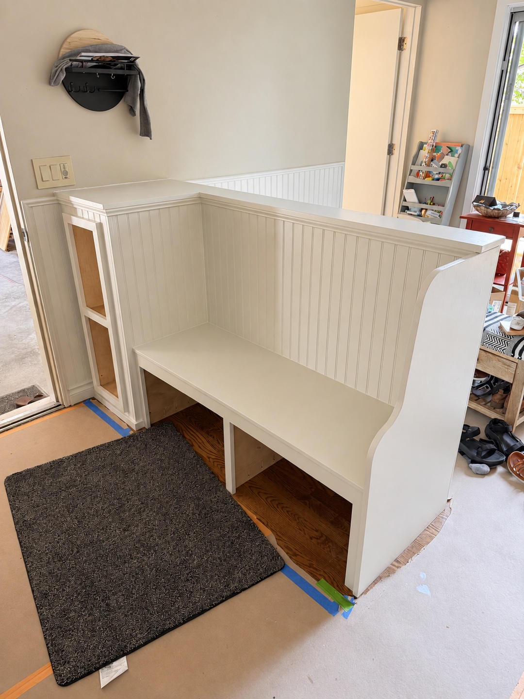 Built-in entry bench with beadboard backing and open storage.